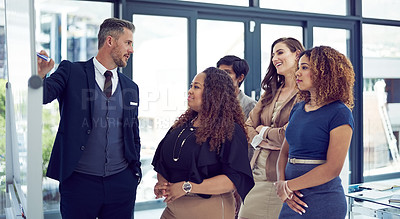 Buy stock photo Cropped shot of a group of businesspeople working on a whiteboard in the boardroom