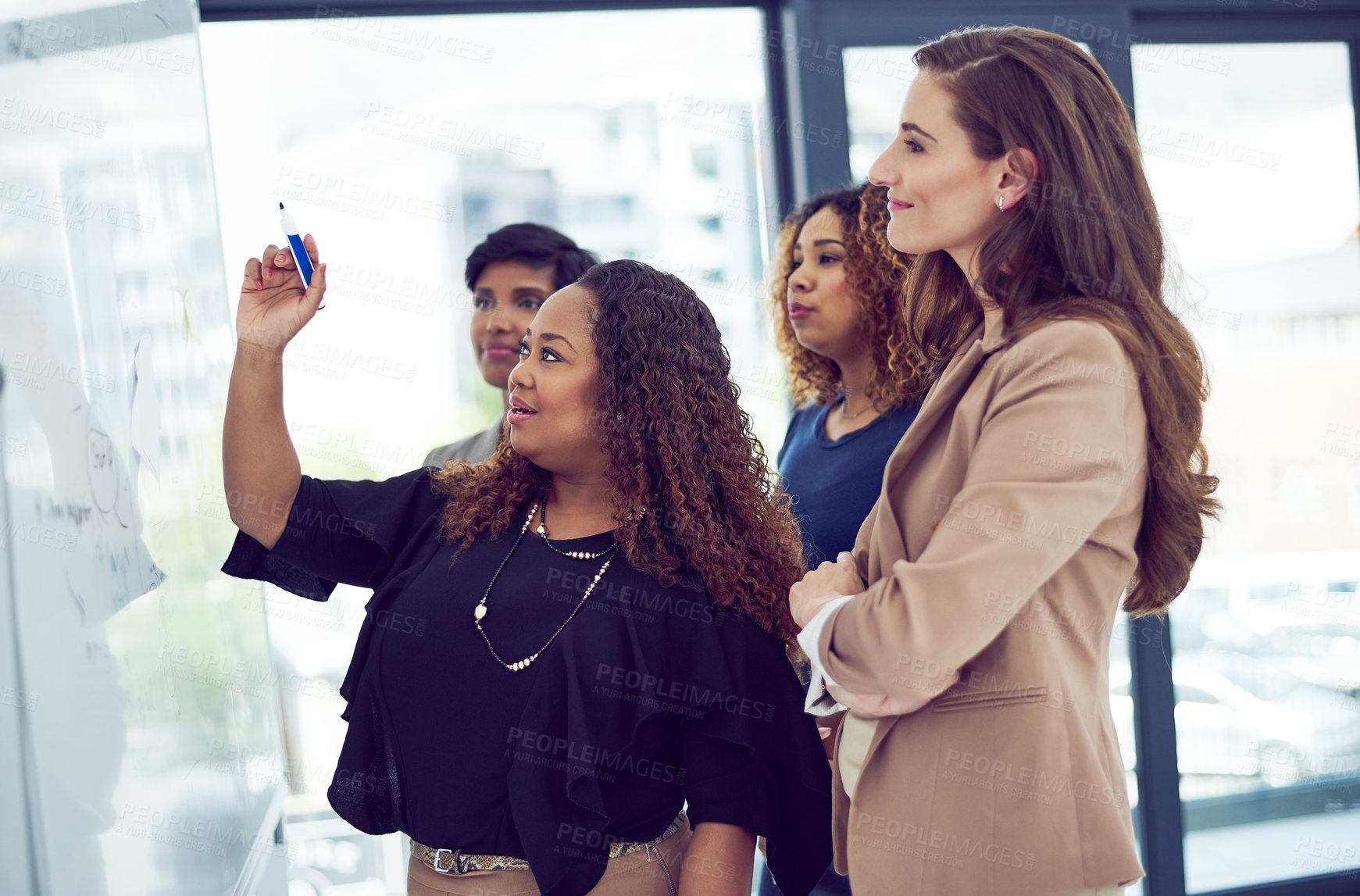 Buy stock photo Cropped shot of a group of businesswomen working on a whiteboard in the boardroom