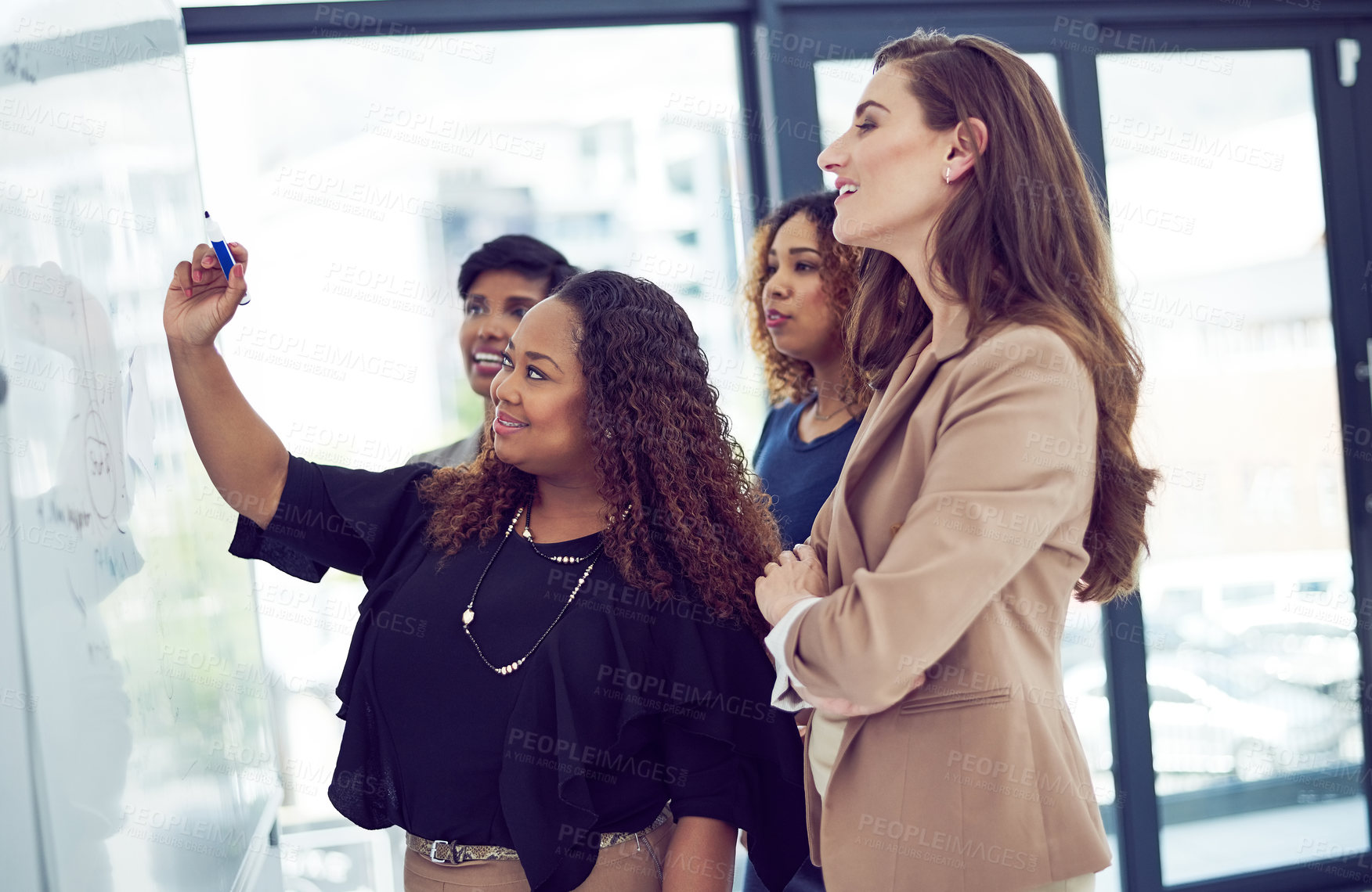 Buy stock photo Cropped shot of a group of businesswomen working on a whiteboard in the boardroom