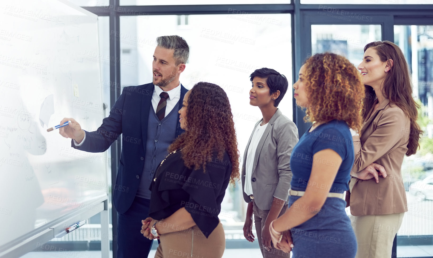 Buy stock photo Cropped shot of a group of businesspeople working on a whiteboard in the boardroom