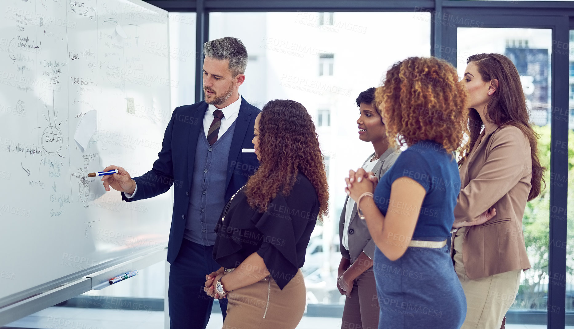 Buy stock photo Cropped shot of a group of businesspeople working on a whiteboard in the boardroom