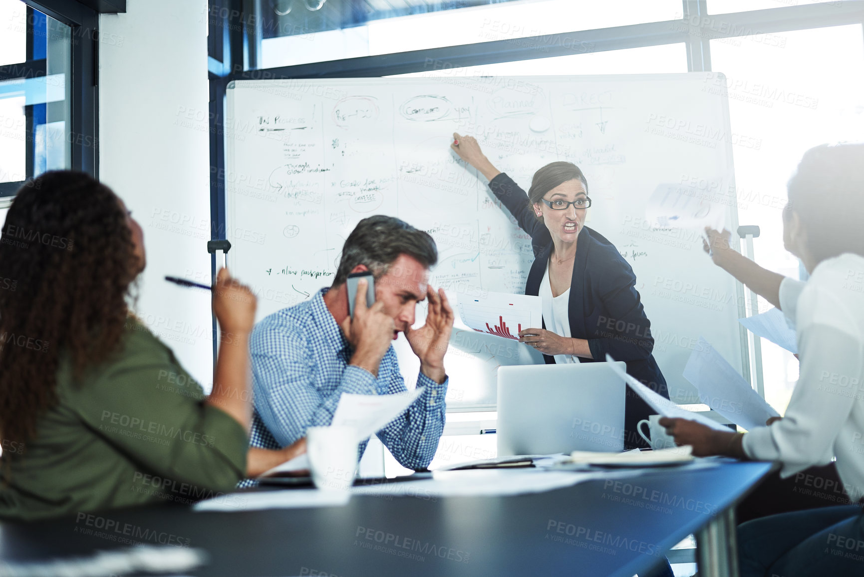 Buy stock photo Shot of a stressed businesswoman losing her temper during a meeting with her colleagues in the boardroom