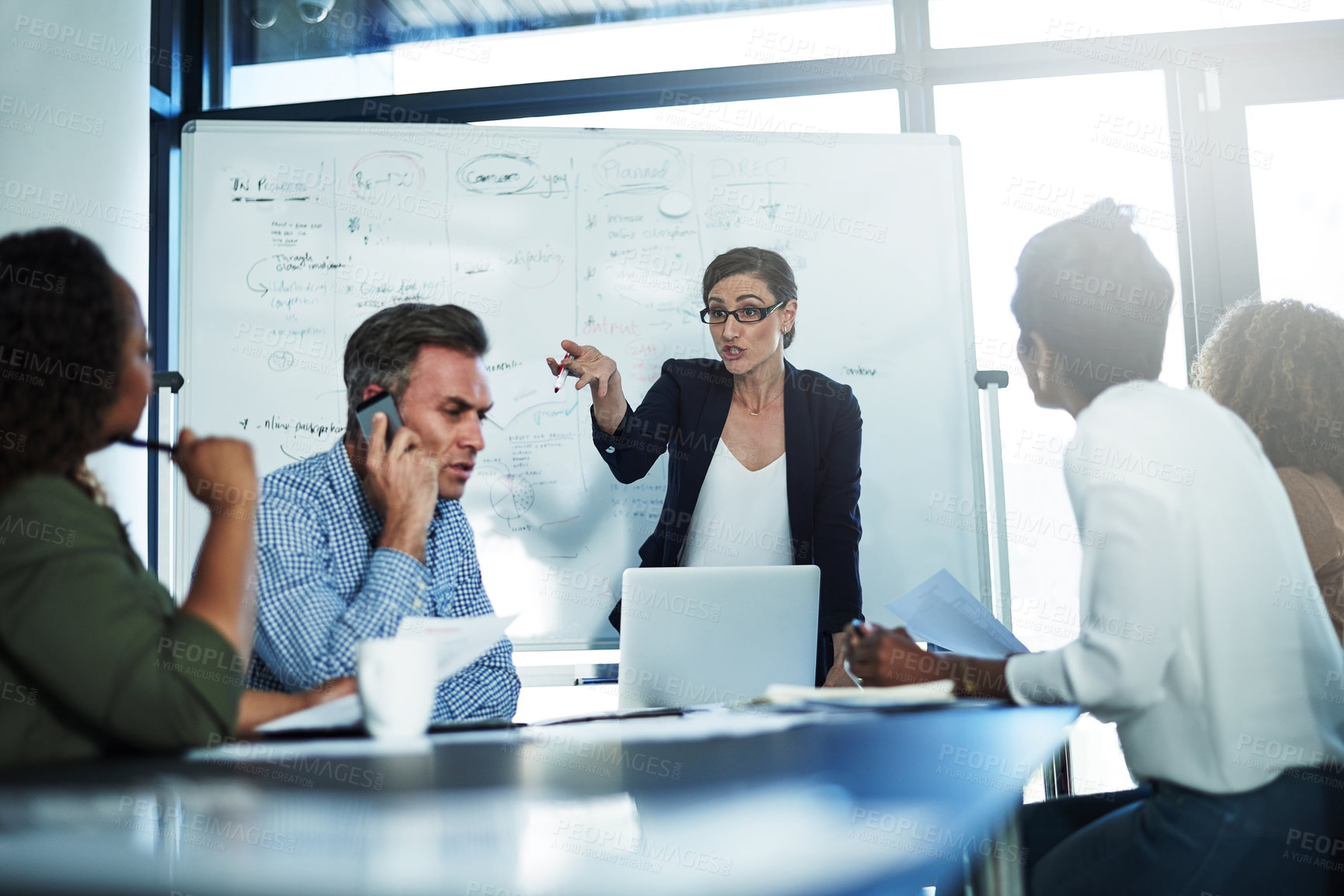 Buy stock photo Shot of a stressed businesswoman losing her temper during a meeting with her colleagues in the boardroom