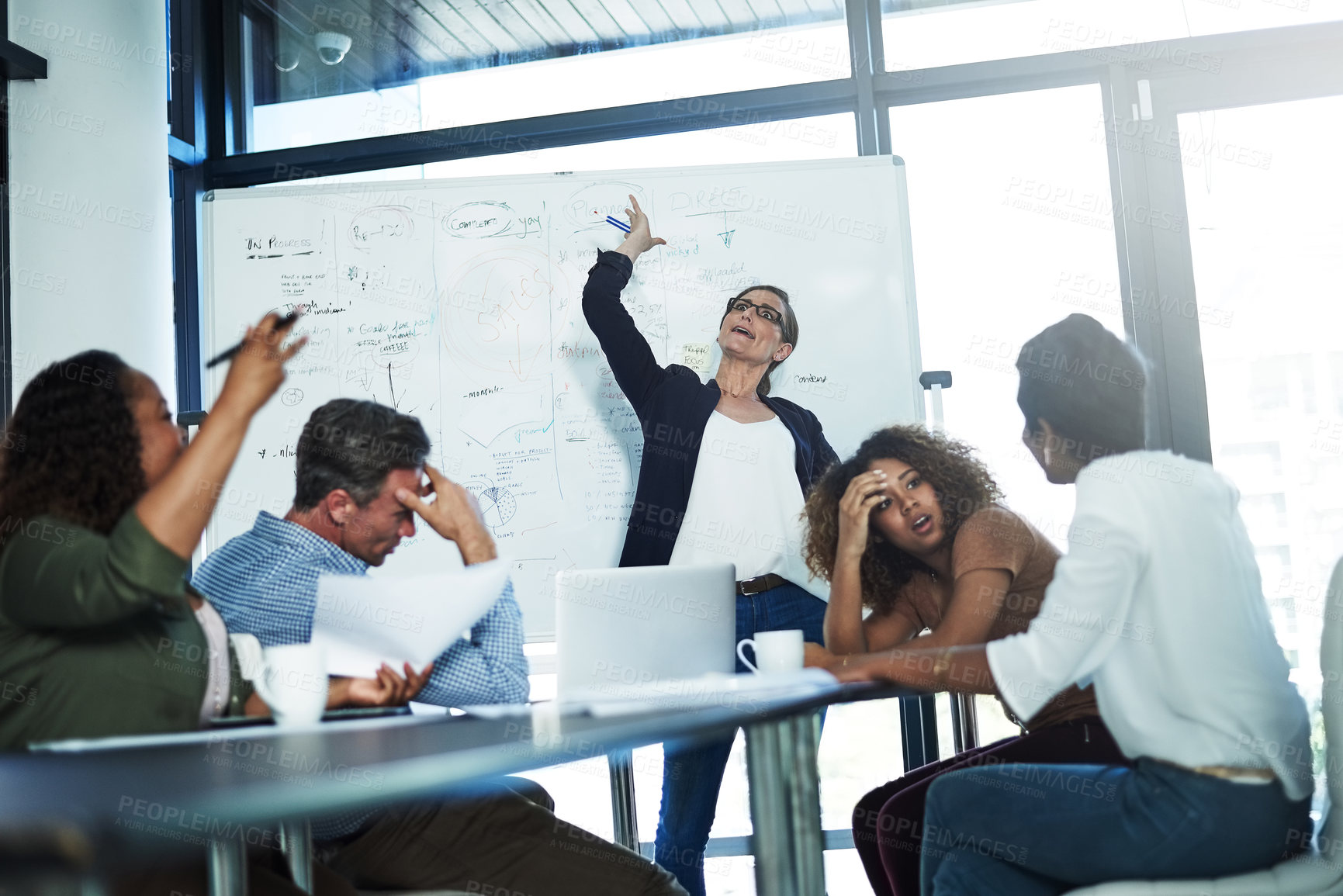 Buy stock photo Shot of a stressed businesswoman losing her temper during a meeting with her colleagues in the boardroom