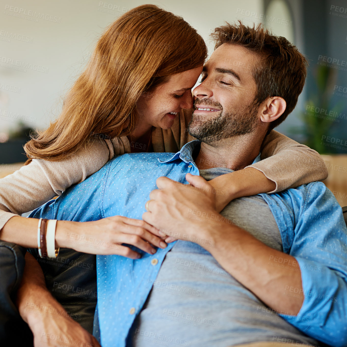 Buy stock photo Cropped shot of an affectionate young couple relaxing on the sofa at home