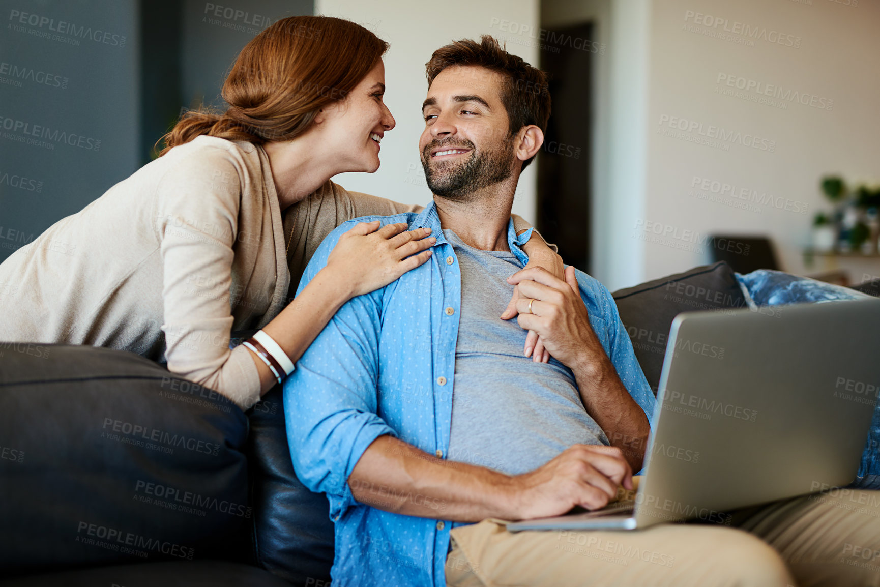 Buy stock photo Hug, laptop and couple on sofa in home planning anniversary vacation, getaway or weekend. Happy, love and woman embracing husband on computer booking hotel on online app for holiday at apartment.