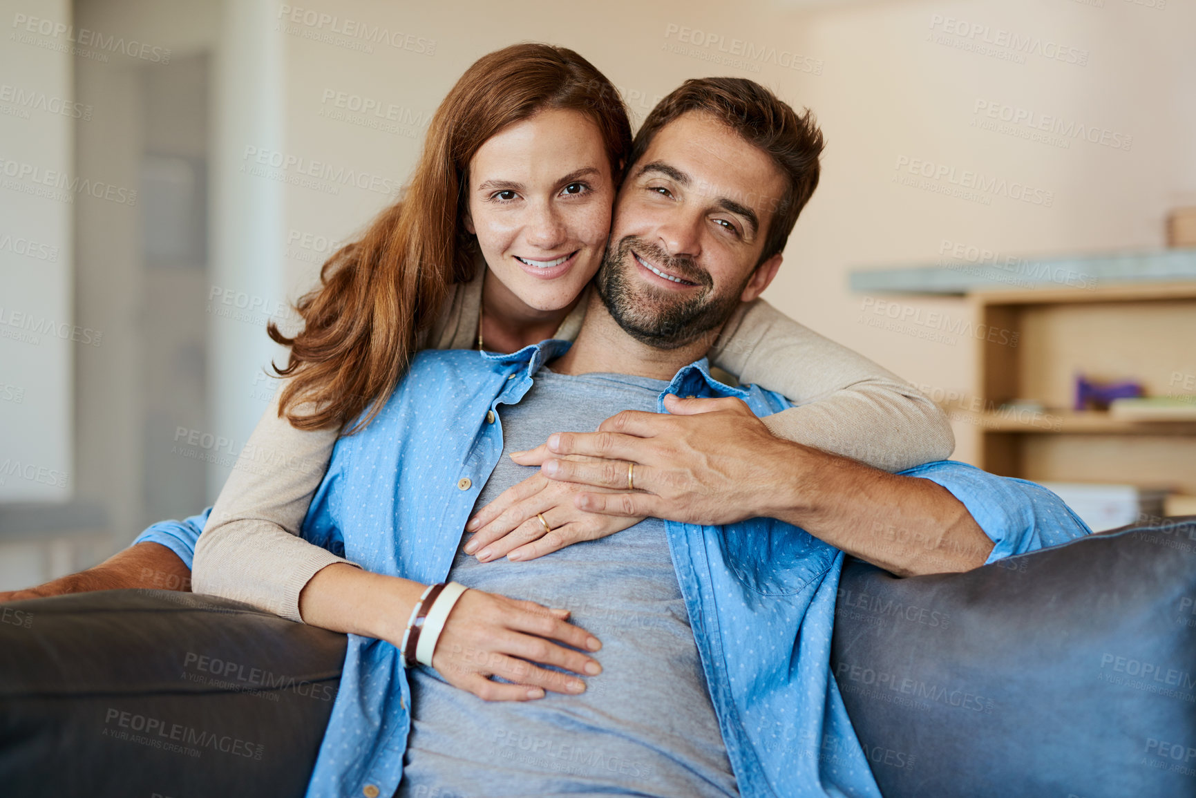 Buy stock photo Cropped portrait of an affectionate young couple relaxing on the sofa at home