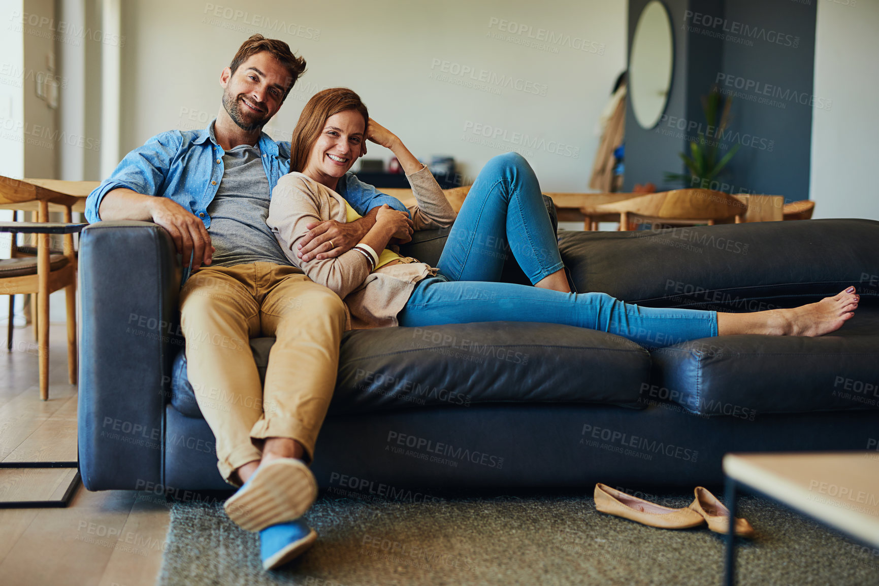 Buy stock photo Full length portrait of an affectionate young couple relaxing on the sofa at home