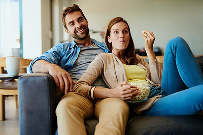 Buy stock photo Cropped shot of an affectionate young couple watching a movie on the sofa at home