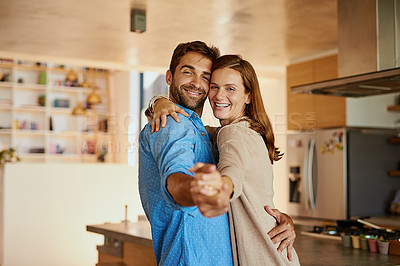 Buy stock photo Cropped portrait of an affectionate young couple dancing in their kitchen