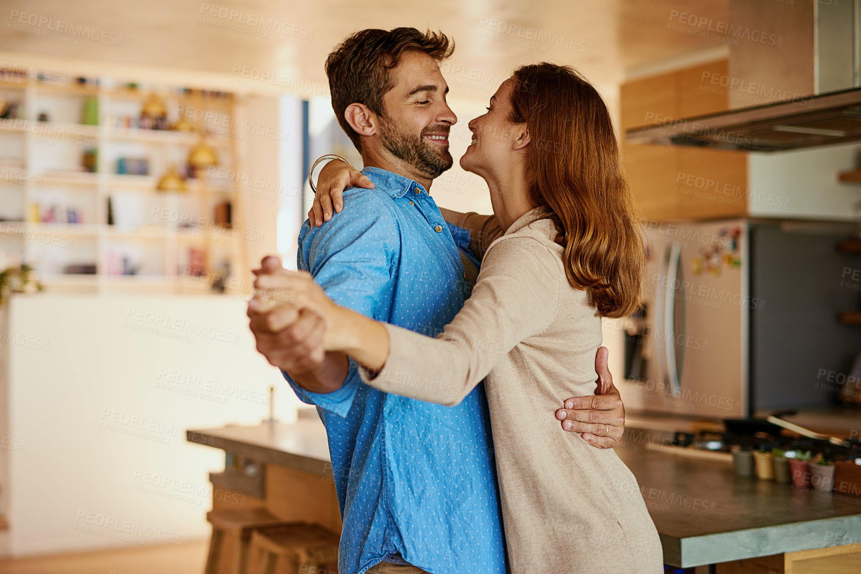 Buy stock photo Happy couple, dancing and together in kitchen for wellness, happiness for anniversary or date. Man, woman and movement in home with support and music, partners with commitment and hug or smile