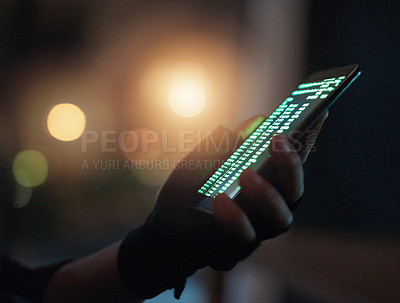 Buy stock photo Shot of an unrecognisable hacker using a cellphone in the dark