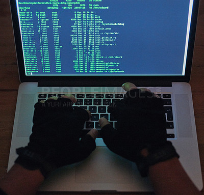 Buy stock photo Shot of an unrecognisable hacker using a laptop in the dark