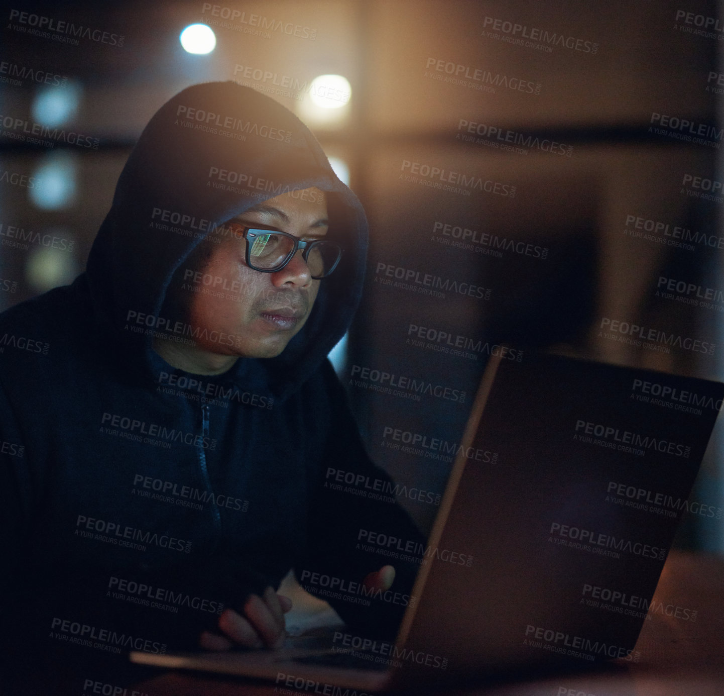 Buy stock photo Shot of a hacker using a laptop in the dark