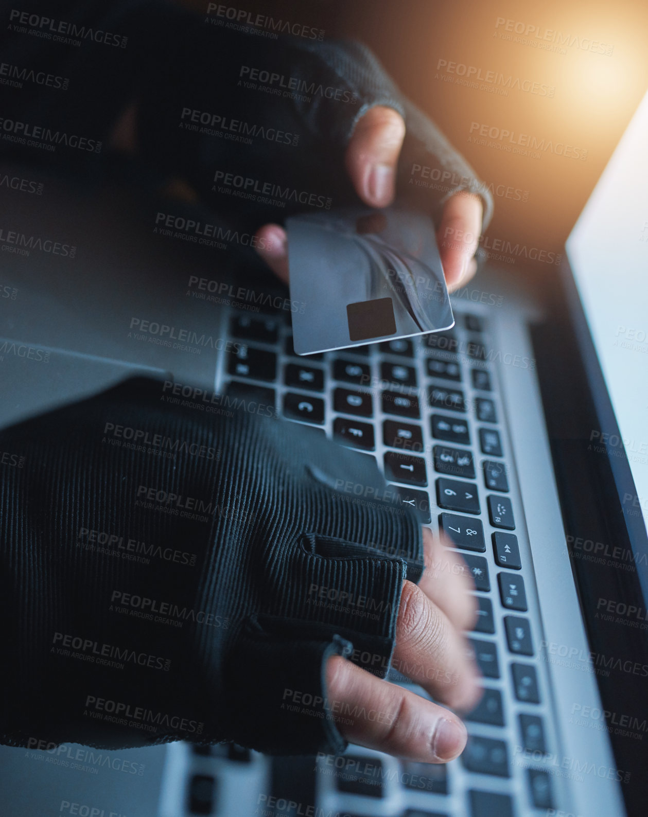 Buy stock photo Shot of an unrecognisable hacker using a laptop to hack into a credit account