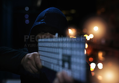 Buy stock photo Shot of an unrecognisable hacker holding a keyboard in the dark