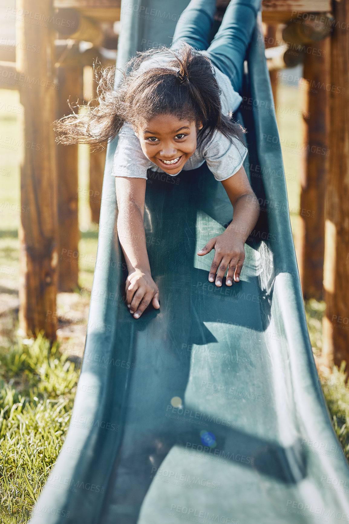 Buy stock photo Slide, playing and portrait of child in park for fun, joy or summer break in countryside. Happy, excited and girl kid on glide for obstacle equipment in outdoor field with smile for school holiday.