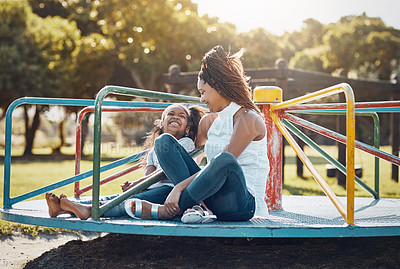 Buy stock photo Woman, young girl together on roundabout at park and playing with smile and fun outdoor. Love, care and bonding with family happiness, mother and daughter enjoying time at playground with freedom