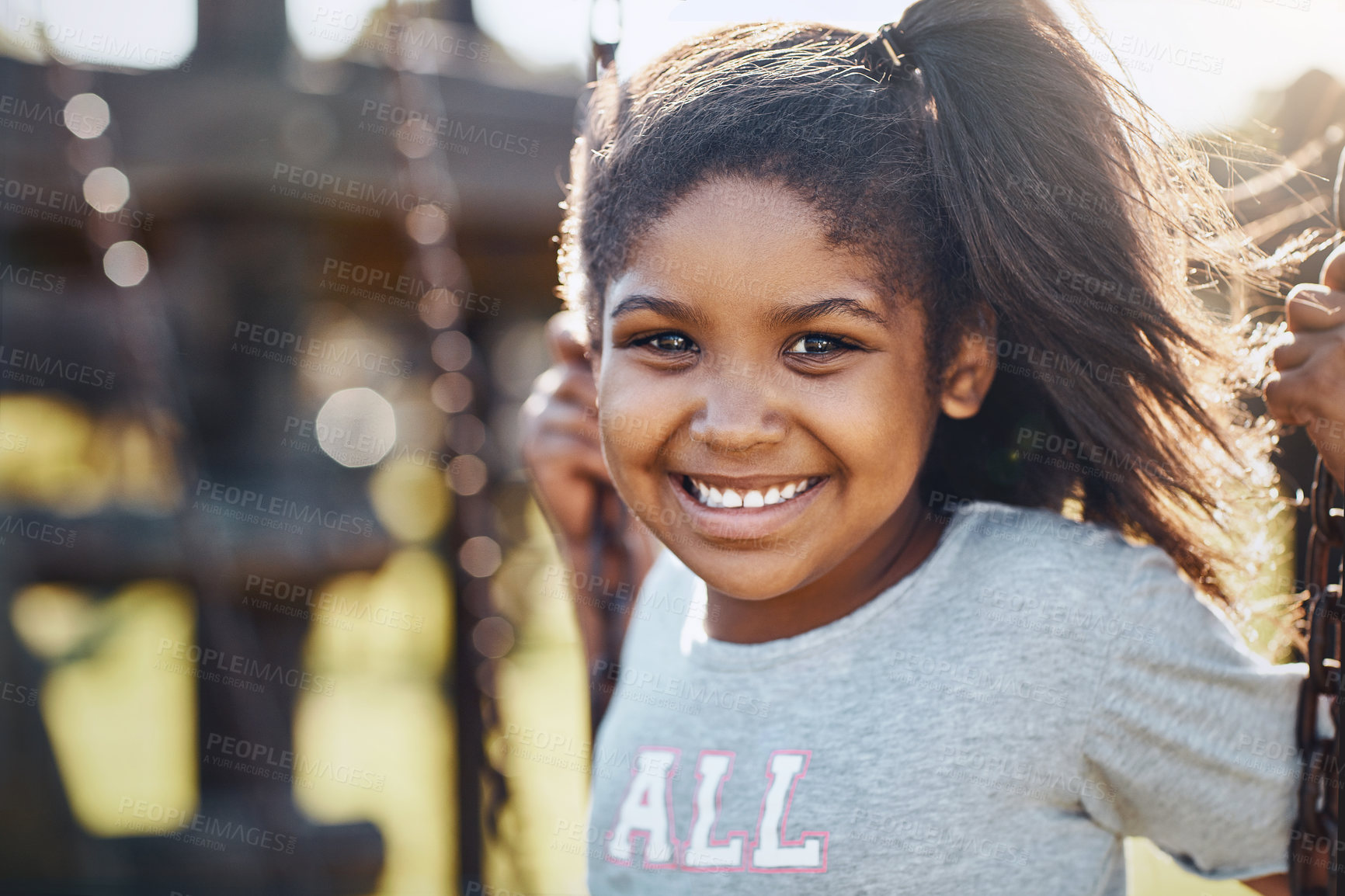 Buy stock photo Portrait of an adorable little girl playing on a swing at the park