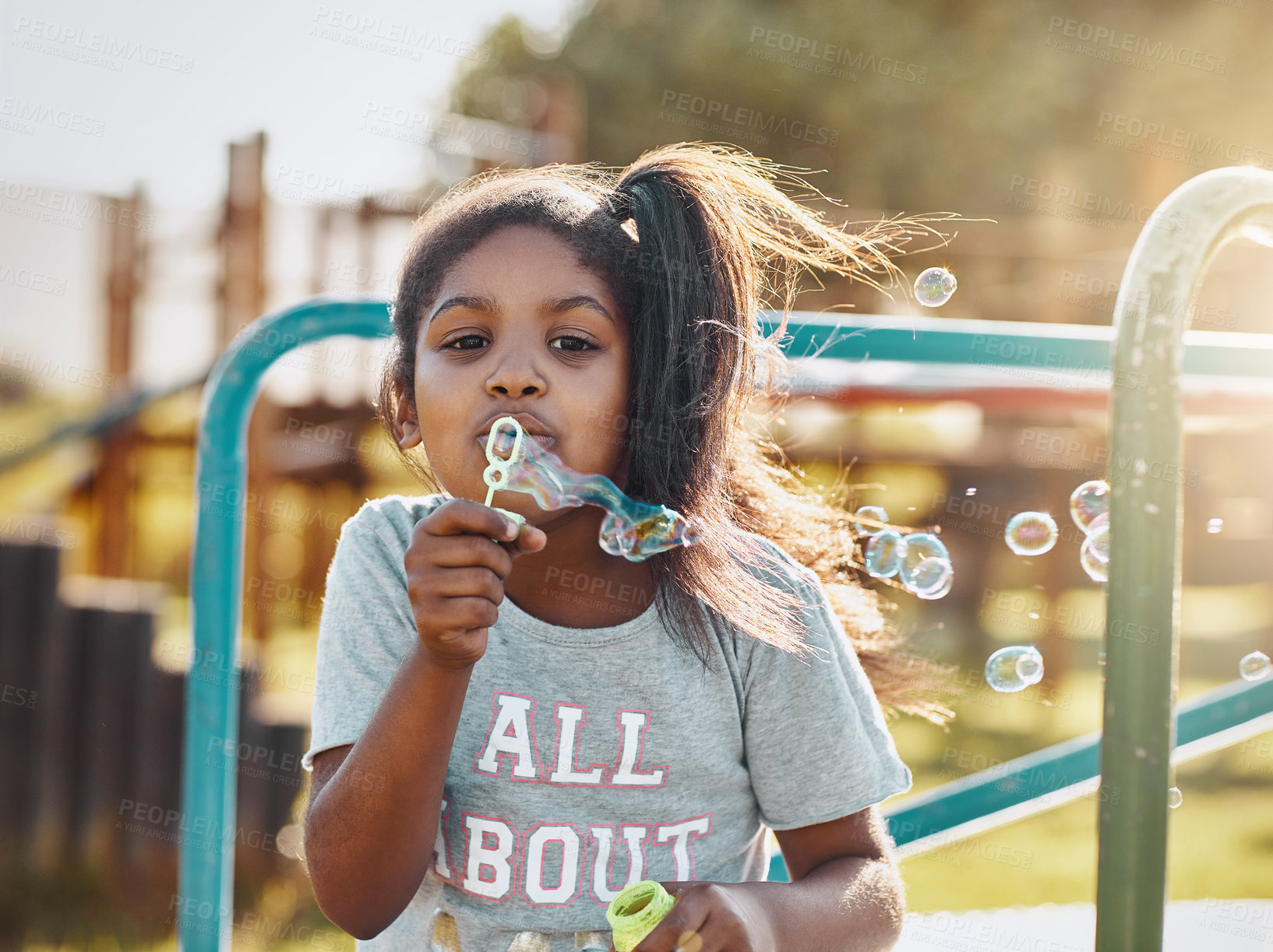 Buy stock photo Portrait, child and bubbles with playground, fun and love for summer break and play. Kid, obstacle course and park equipment for joy, outside and happy girl smile with countryside merry go round