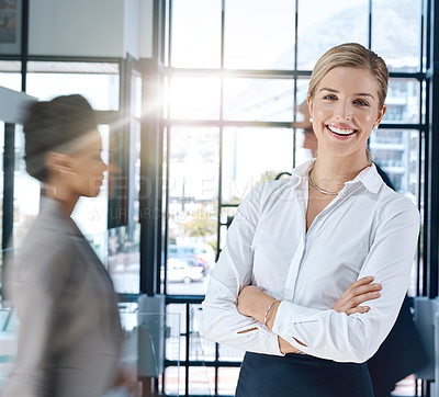 Buy stock photo Shot of an confident and attractive businesswoman standing and smiling in the office with her arms folded
