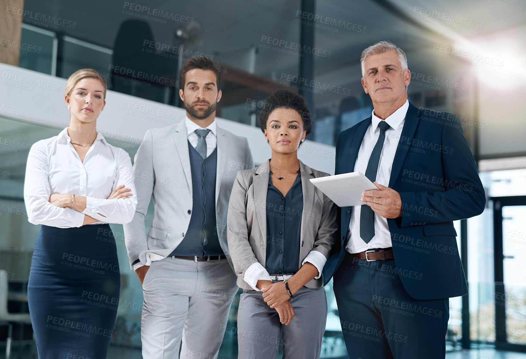 Buy stock photo Shot of a professional and confident business team standing and working in their office