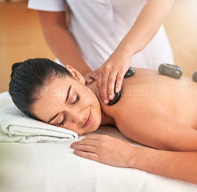 Buy stock photo Cropped shot of an attractive young woman enjoying a hot stone massage at a spa