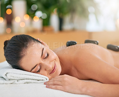 Buy stock photo Cropped shot of an attractive young woman enjoying a hot stone massage at a spa