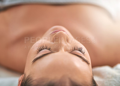 Buy stock photo Cropped shot of an attractive young woman relaxing on a massage table at a spa