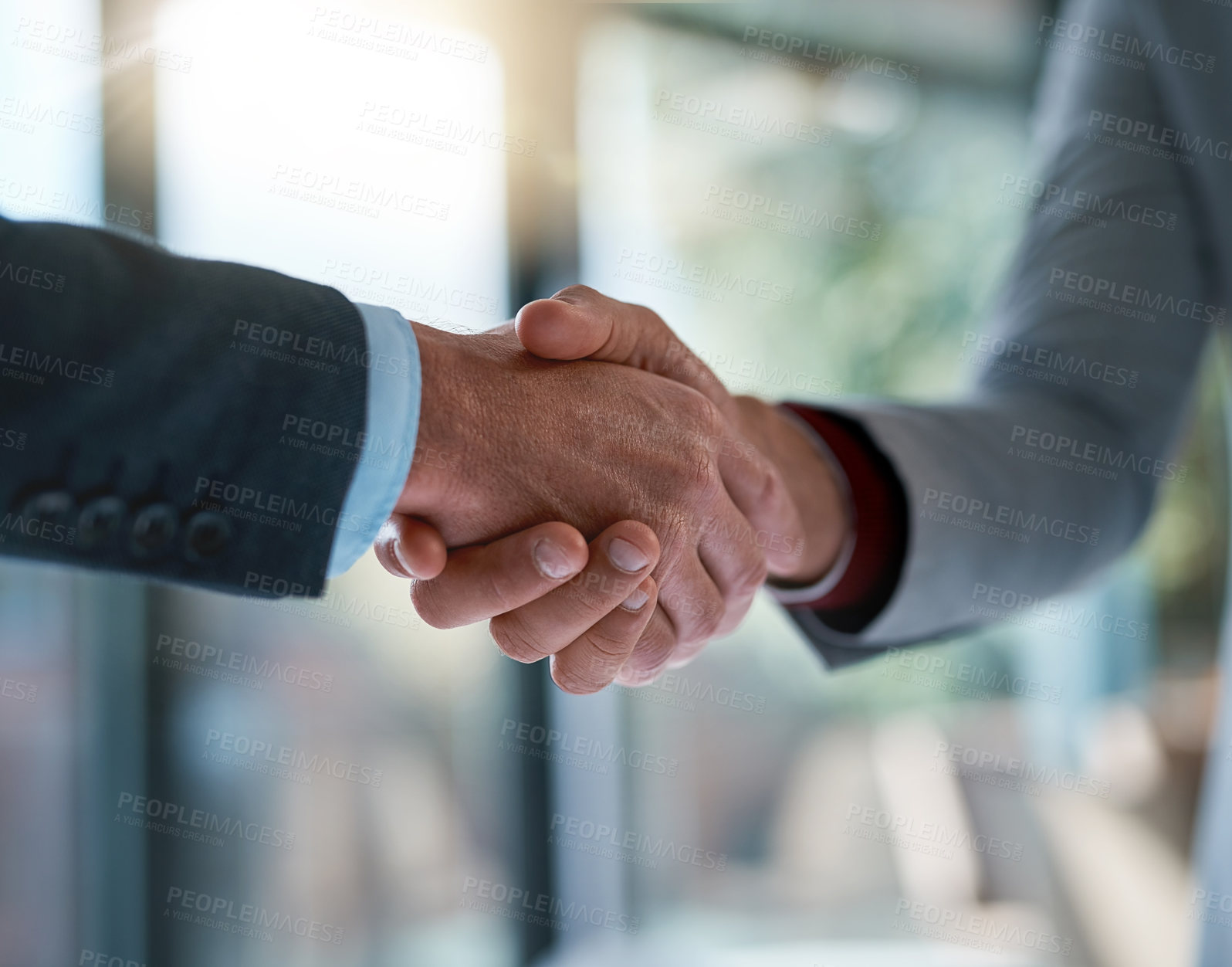 Buy stock photo Cropped shot of two unrecognizable businessmen shaking hands after making a deal in the office