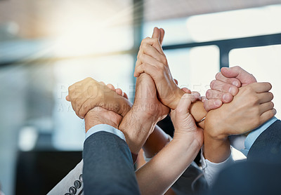 Buy stock photo Cropped shot of a group of unrecognizable businesspeople holding hands in a gesture of unity in the office