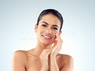 Buy stock photo Studio shot of an beautiful young woman feeling her skin against a gray background