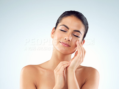 Buy stock photo Studio shot of an beautiful young woman feeling her skin against a gray background