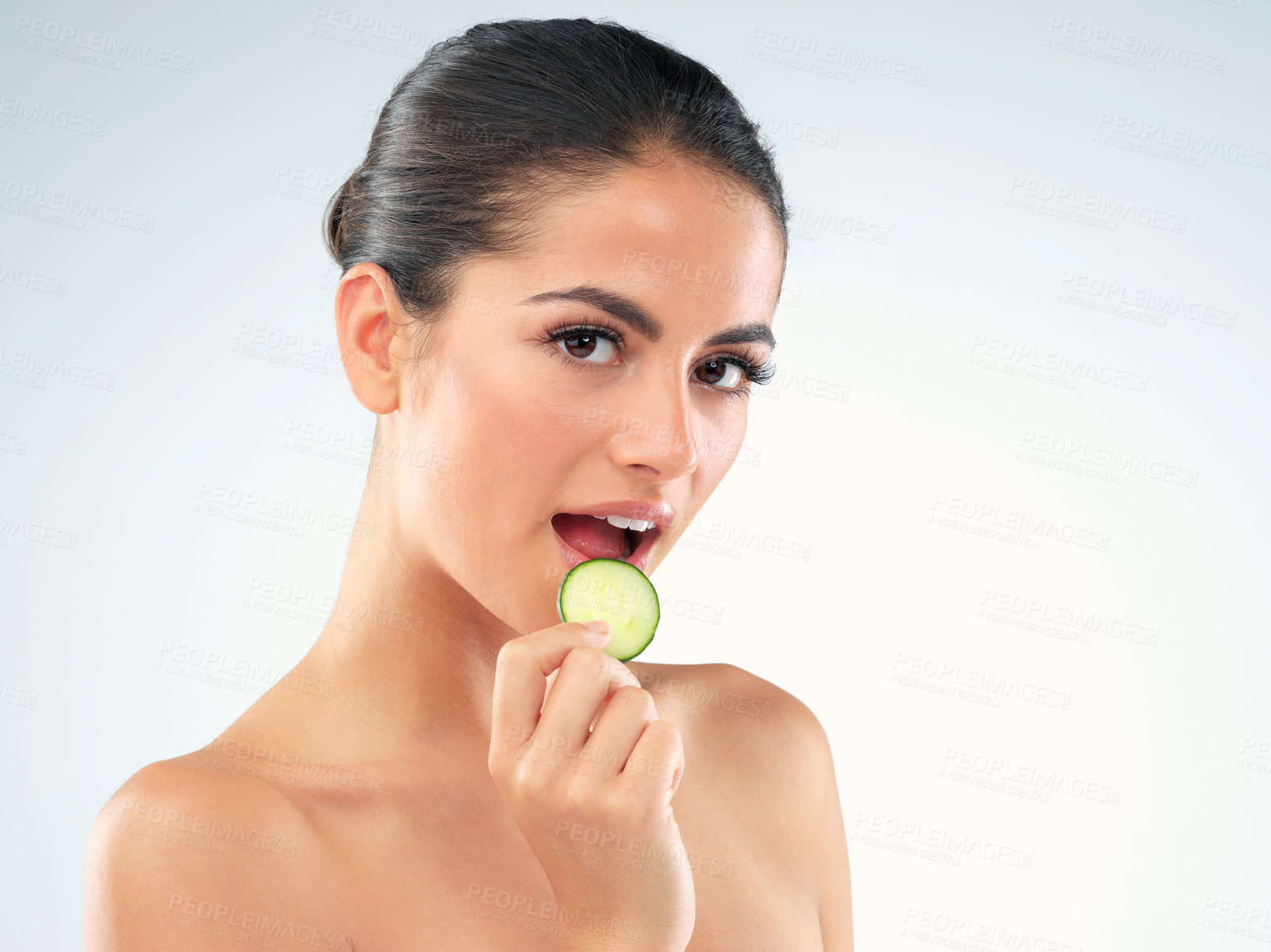 Buy stock photo Beauty, portrait and woman eating in studio with cucumber for facial routine, sjkincare or glow with white background. Body, mockup and hand of model for clean, organic treatment or nutrition