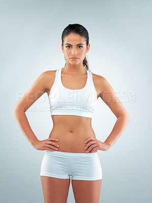 Buy stock photo Studio shot of a beautiful and fit young woman wearing sports clothing against a gray background