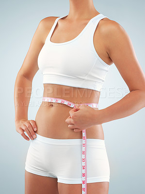 Buy stock photo Woman, hands and tape measure on abdomen in studio for tracking weight loss of thermogenesis and progress. Girl, white background and monitor calorie burn of metabolic booster and appetite control.