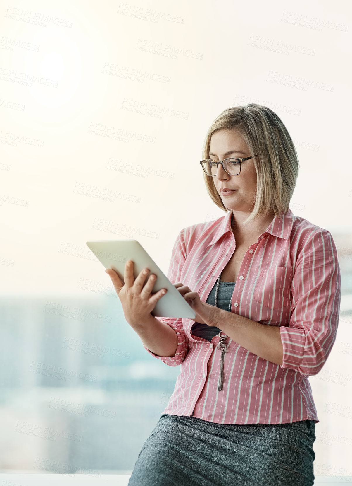 Buy stock photo Cropped shot of a businesswoman using a digital tablet in an office