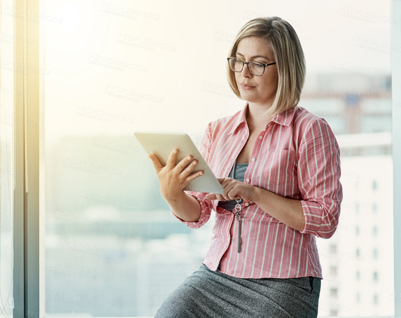 Buy stock photo Cropped shot of a businesswoman using a digital tablet in an office