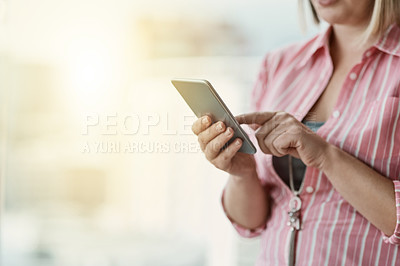 Buy stock photo Cropped shot of an unidentifiable businesswoman using a cellphone in an office