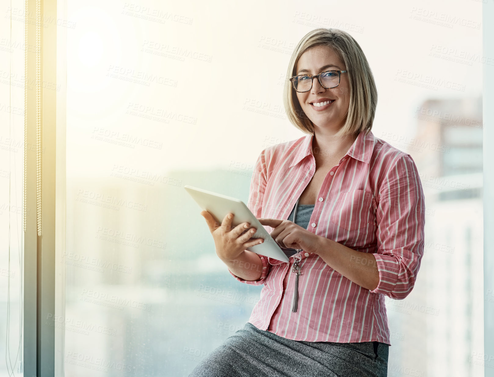 Buy stock photo Portrait of a confident businesswoman using a digital tablet in an office