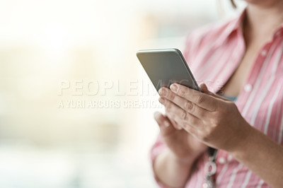 Buy stock photo Cropped shot of an unidentifiable businesswoman using a cellphone in an office