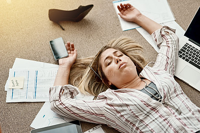 Buy stock photo High angle shot of a stressed out businesswoman lying on the floor in an office