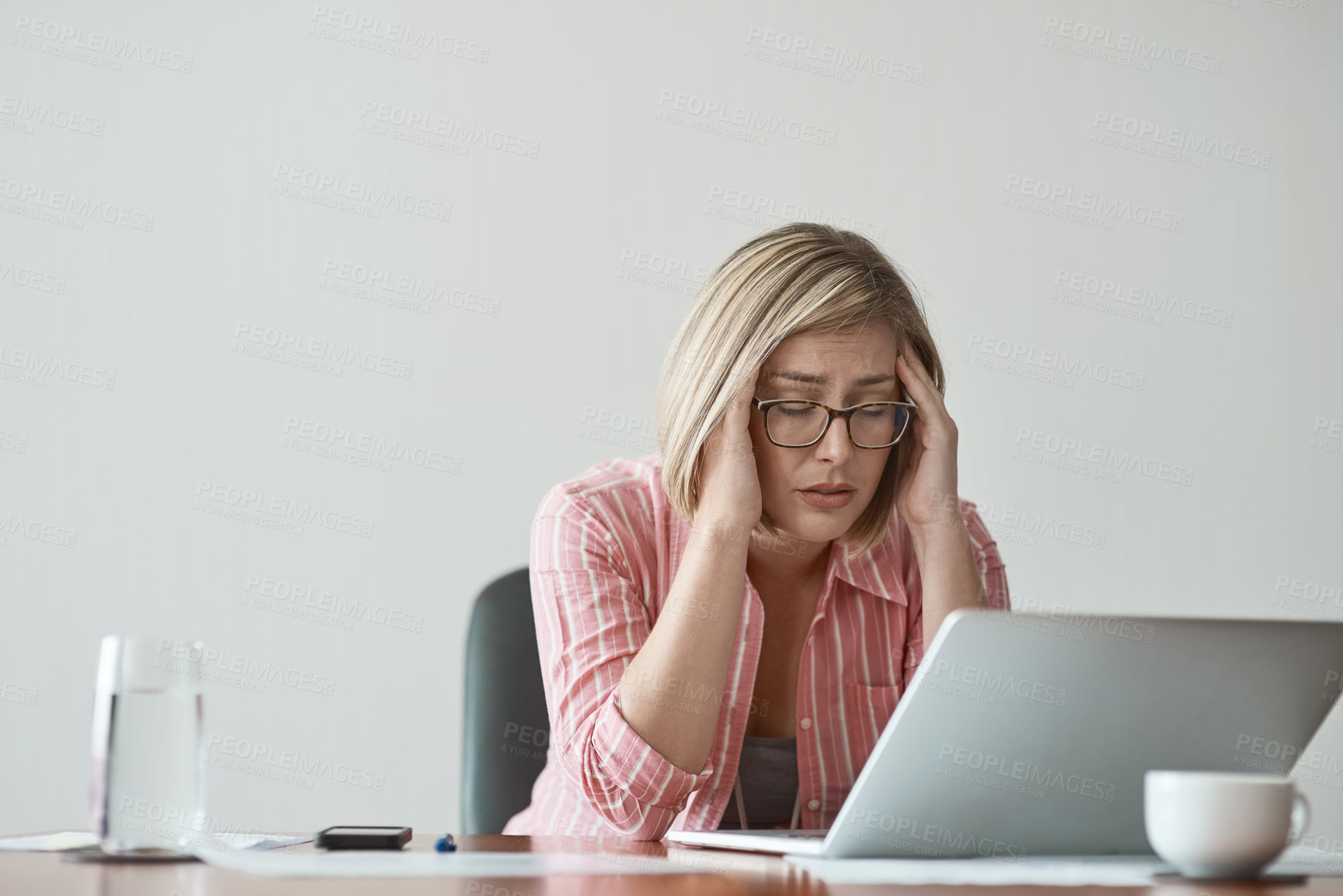 Buy stock photo Studio shot of a businesswoman looking stressed out while working on a laptop against a grey background