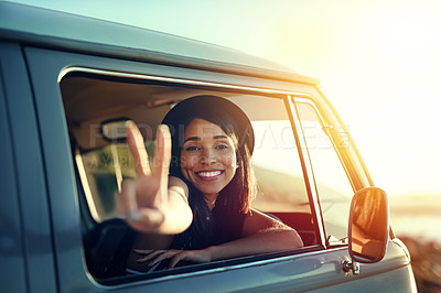 Buy stock photo Shot of a young woman leaning out of a van’s window and showing a peace sign on a roadtrip