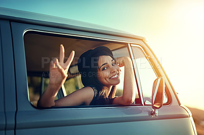 Buy stock photo Shot of a young woman leaning out of a van’s window and showing a peace sign on a roadtrip