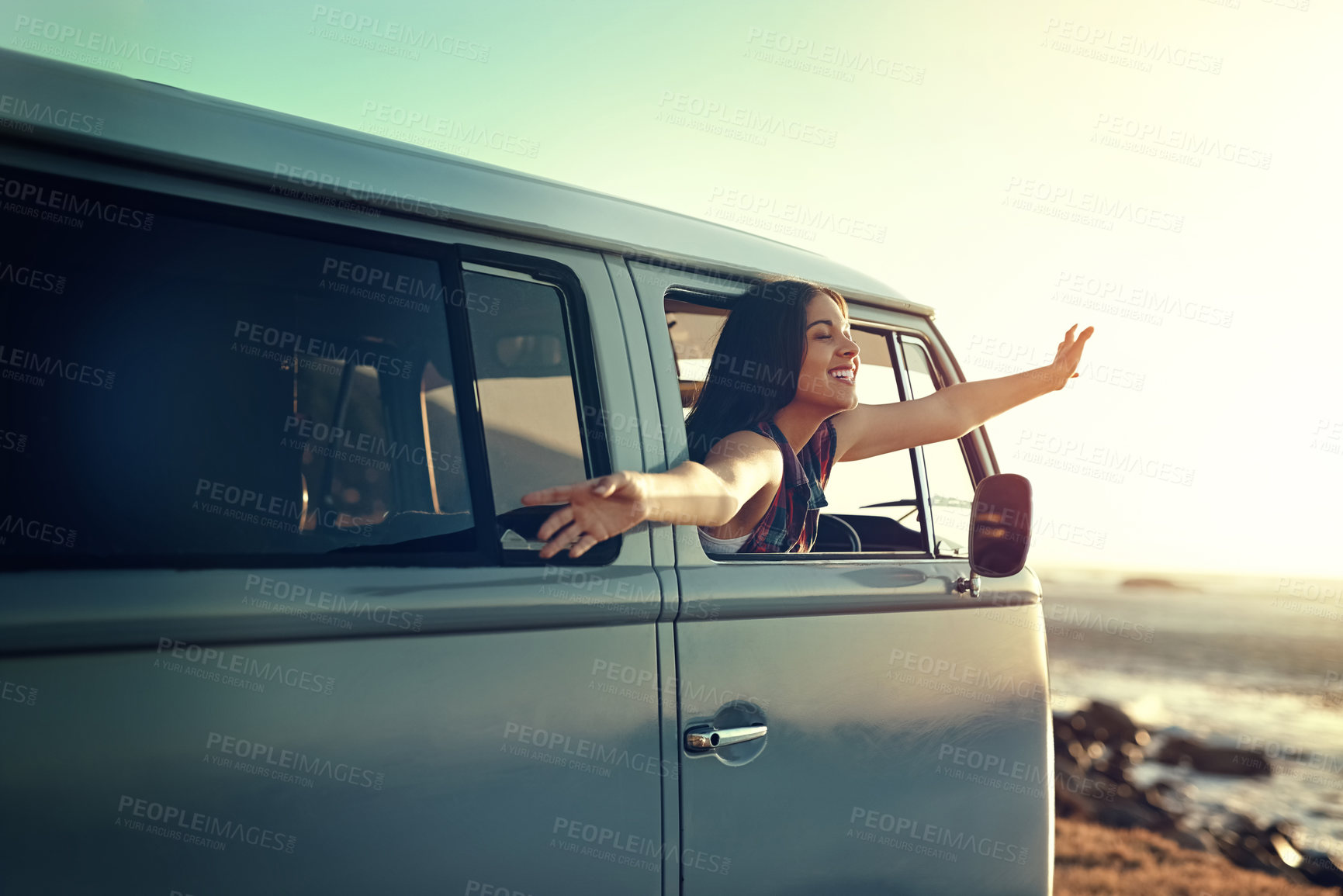 Buy stock photo Shot of a young woman leaning out of her van's window with her arms outstretched