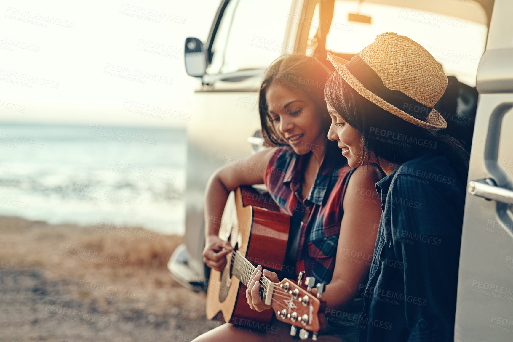 Buy stock photo Van, road trip and women at a beach with guitar for sunset, adventure and music while bonding on vacation in nature. Caravan, travel or friends at sea with acoustic instrument, song or fun in Mexico 