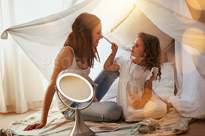 Buy stock photo Shot of a mother and daughter having fun and playing around with makeup