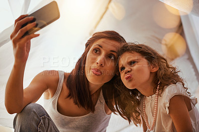 Buy stock photo Shot of a mother and daughter having fun and taking a photo together while pulling a face