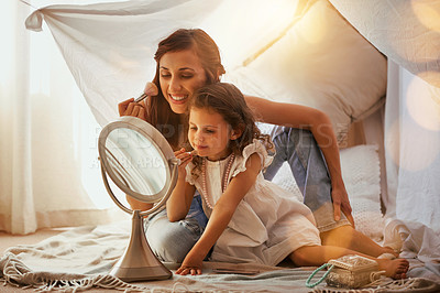 Buy stock photo Shot of a mother and daughter having fun and playing around with makeup